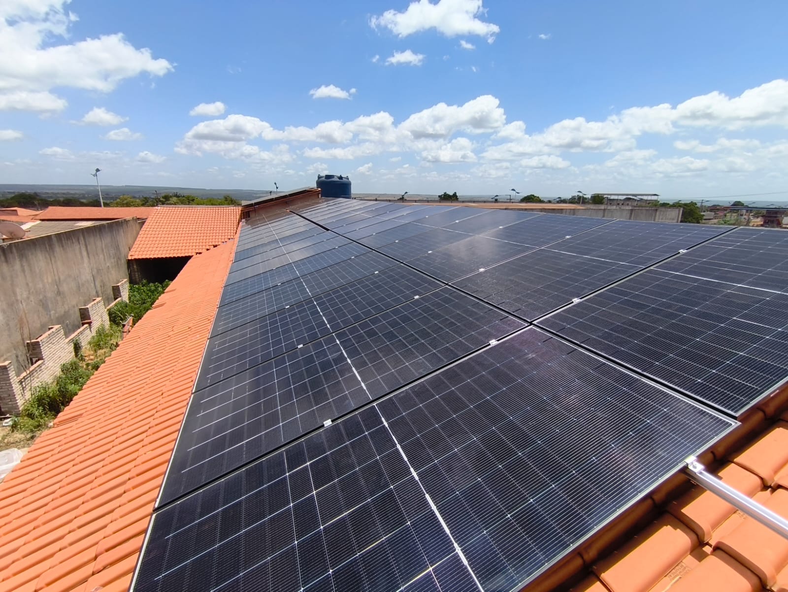 Instalação DRM em Bom Jesus das Selvas, Maranhão: painéis solares sobre telhas alaranjadas, sob céu azul